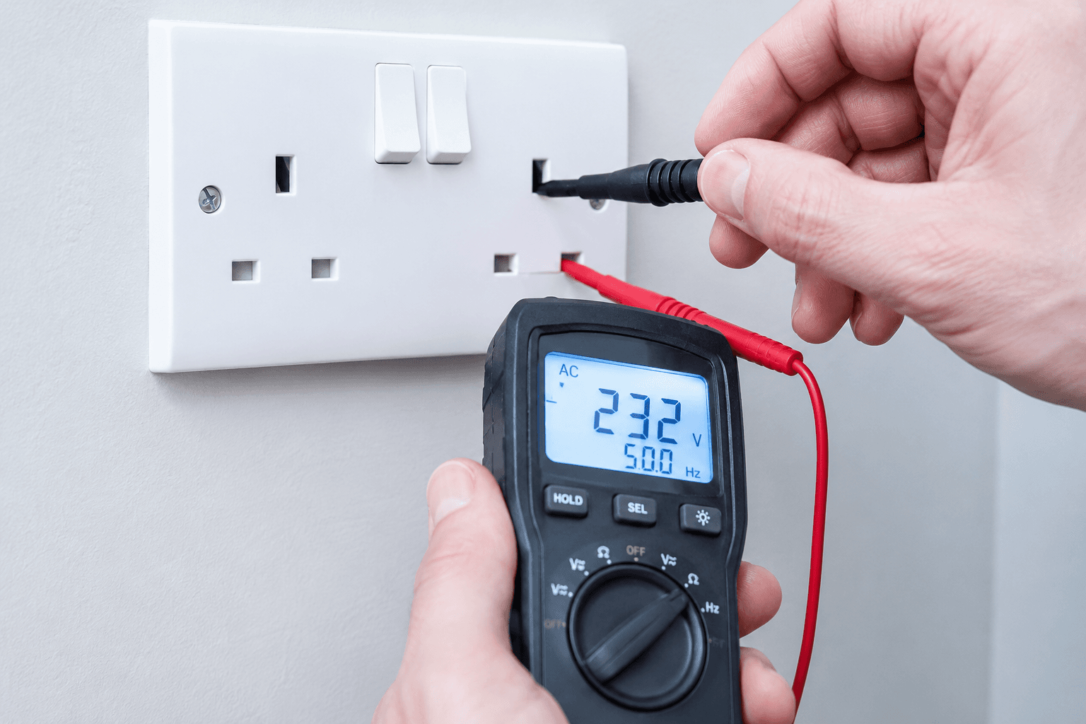 Electrician testing a UK socket with a multimeter for polarity and earth continuity during an EICR